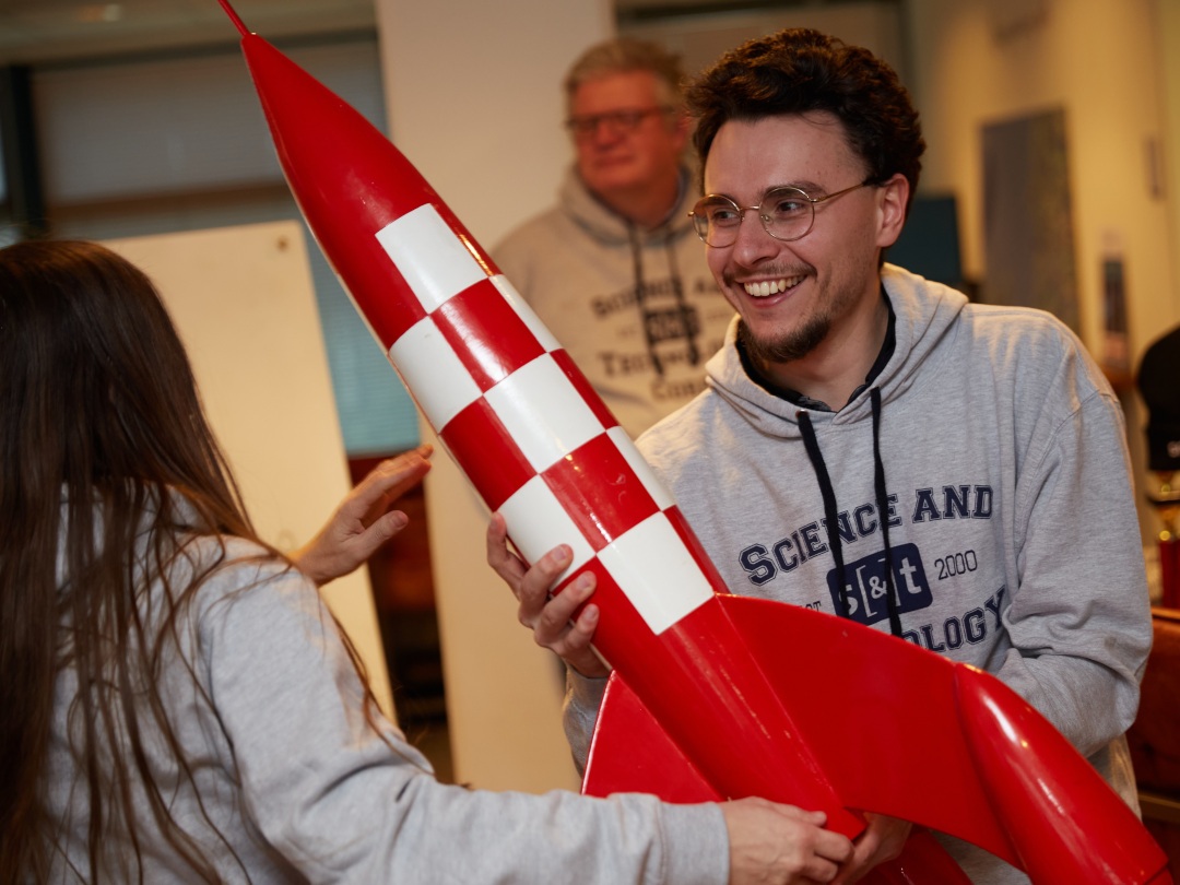 Easter Game winner Quentin Leroy (in foreground) receiving the prize from Carina Maas-Olij (with her back on the picture). In the background Andé Bos smiling.